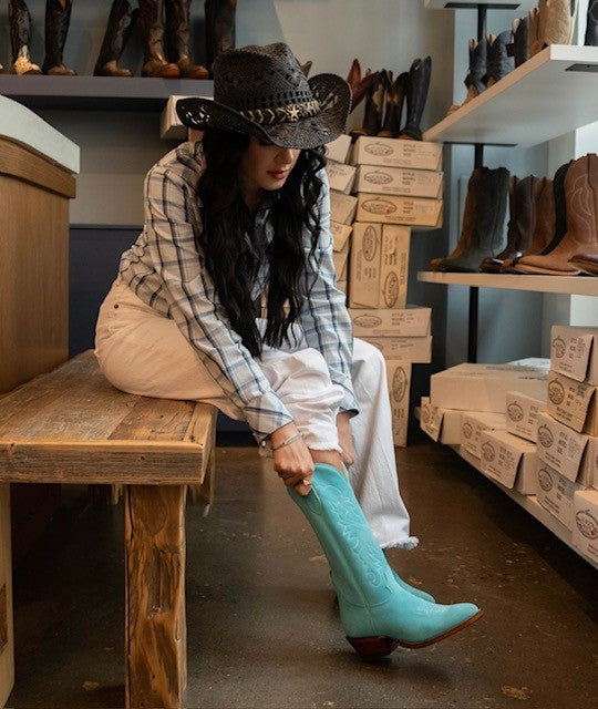 
                  
                    Woman putting on light blue suede modern boot
                  
                